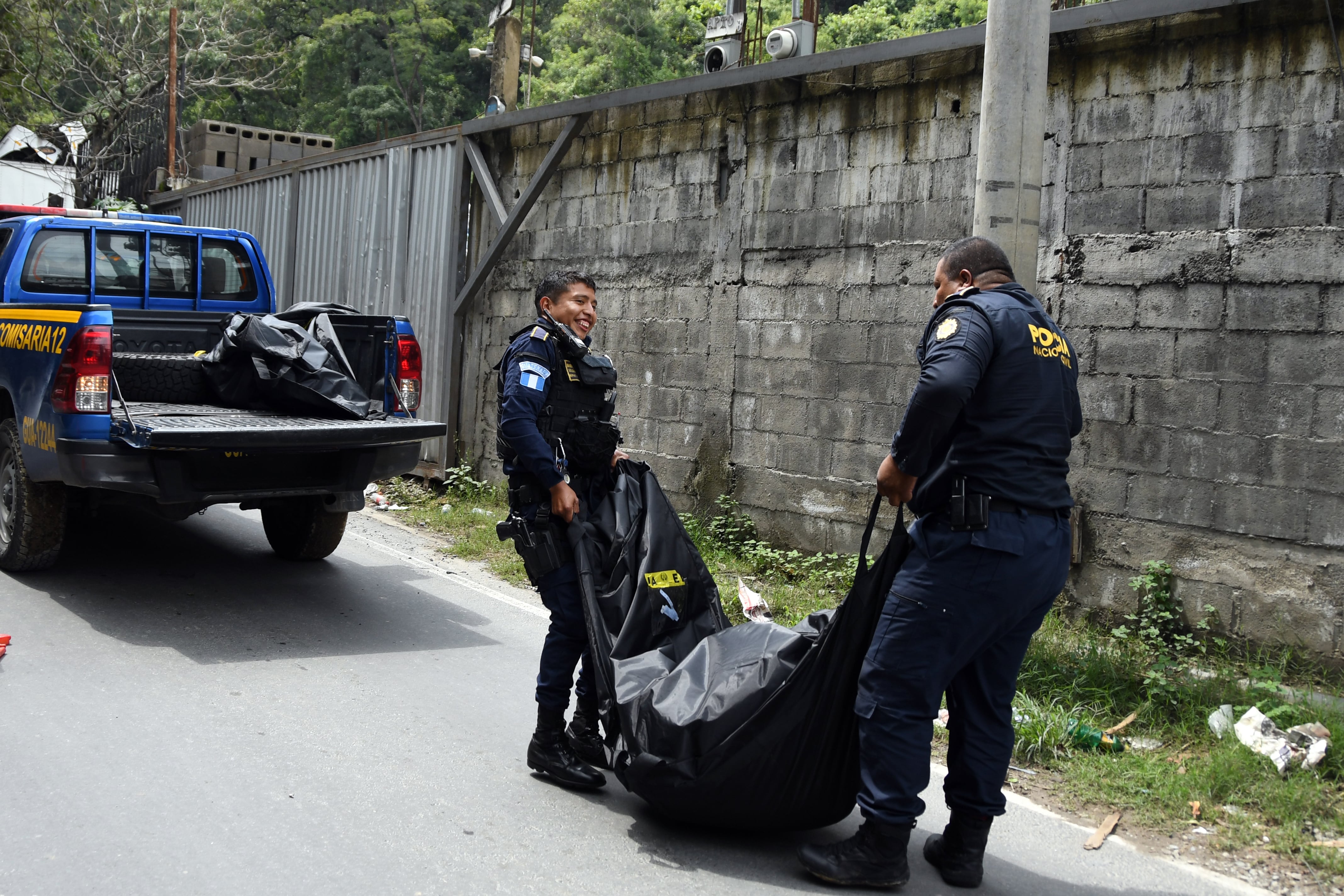 AME5916. CIUDAD DE GUATEMALA (GUATEMALA), 14/10/2026.- Fotografía del 28 de septiembre de 2026 que muestra a dos integrantes de la Policía Nacional Civil (PNC) levantando un cadáver a un costado de la carretera antigua que conduce a Chinautla (Guatemala). EFE/ Alex Cruz