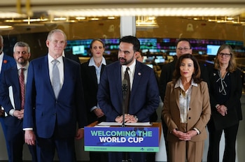 El alcalde Zohran Mamdani hablando en un podio con la gobernadora Kathy Hochul y otros funcionarios presentes. Hay una pancarta que dice 'Welcoming the World Cup'