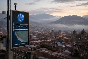 Pantalla con el logo del Instituto Geofísico del Perú, gráficas de ondas y un mapa sísmico ante una ciudad con casas de teja y montañas.