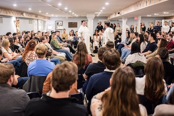 Después de la misa, los jóvenes asistentes se dirigen a In Vino Veritas para disfrutar de vino, queso y una charla teológica. (Bryan Anselm/Para The Washington Post)
