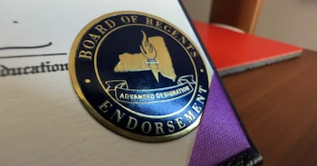 Primer plano de un sello redondo azul y dorado en un documento oficial, con el texto 'Board of Regents' y 'Advanced Designation', y un mapa de Nueva York