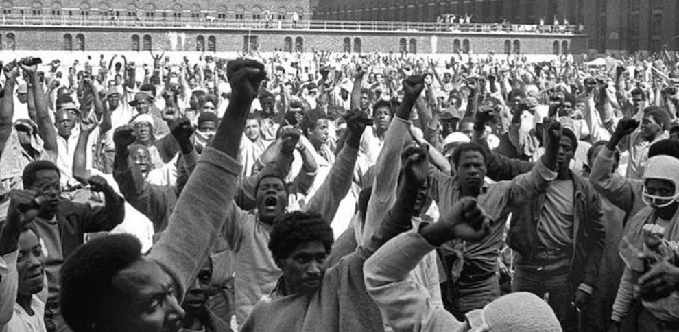 10 de septiembre de 1971: los reclusos amotinados de la cárcel de Attica, puño en alto, gritan sus reivindicaciones durante la visita de la comisión negociadora