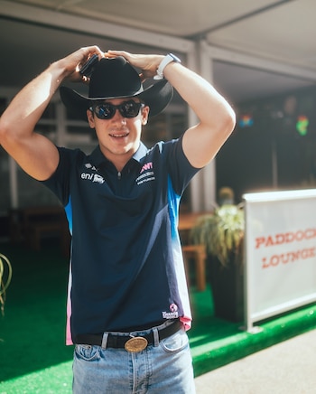 Franco sorprende con una remera tipo polo azul marino, jeans celestes, cinturón negro, sombrero de ala ancha y gafas oscuras (@AlpineF1Team)