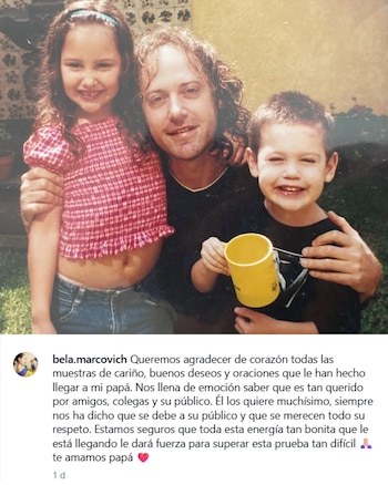 Fotografía vintage de un hombre adulto con cabello rizado sonriendo junto a una niña y un niño. La niña usa una blusa a cuadros rojos y el niño sostiene una taza amarilla