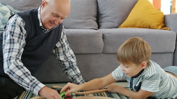 Un abuelo jugando con su nieto en casa (Pexels)