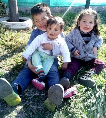 Patricio Zabala junto a Milagros, la hermanita a la que le salvó la vida, en sus brazos, y Romina