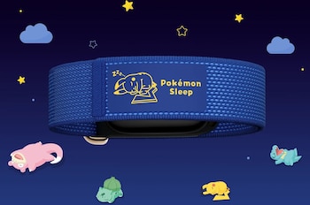 Brazalete textil azul con etiqueta de Pokémon Sleep y Pikachu durmiendo, rodeado por estrellas y pequeñas criaturas sobre fondo azul oscuro