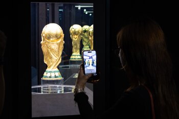 Fotografía de Carlos Ramírez, en la que puede verse en una imagen de archivo del pasado 3 de mayo a una persona tomando una fotografía del trofeo de la Copa Mundial de la FIFA 2026. EFE