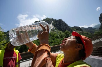 Un trabajador se refresca este