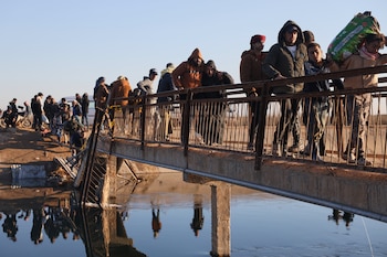 Sirios desplazados cruzan un río