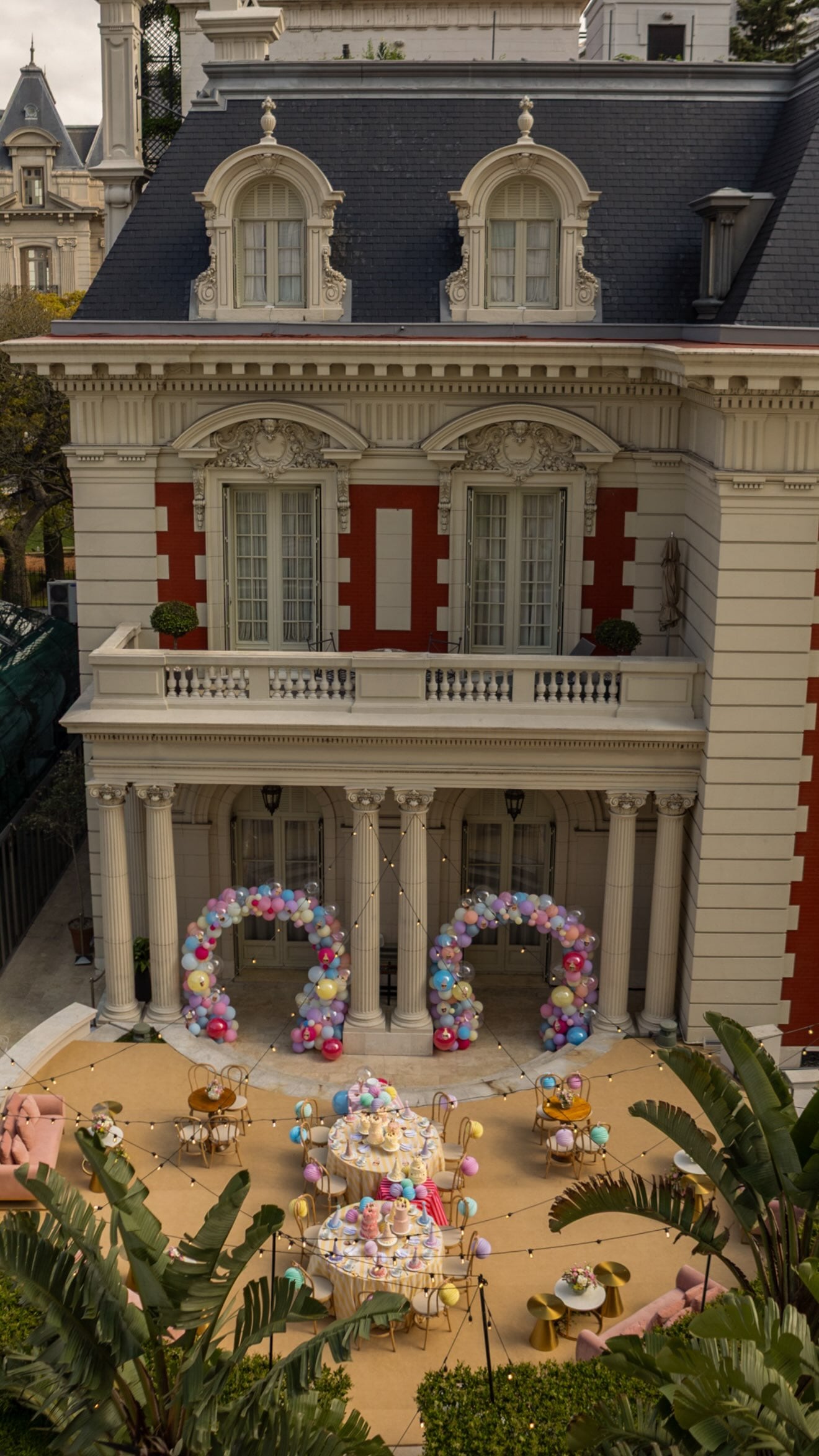 El exterior presenta mesas preparadas, arcos de globos y luces colgantes dispuestos para el festejo de cumpleaños de Isabella Icardi.