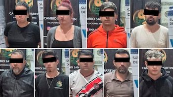 Ocho personas, dos mujeres y seis hombres con los ojos censurados, posan para la cámara frente a un fondo con logos de cambio de divisas y billetes