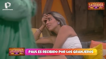 Gabriela Herrera, con cabello rubio y top blanco, sentada y con la mano en la frente, con expresión de preocupación. Se ven logotipos de Panamericana y 'La Granja VIP'