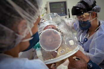 Trabajadores de la salud atienden con un casco burbuja a un paciente con la covid-19 en la ciudad de Sao Leopoldo (Brasil), en una fotografía de archivo. EFE/Daniel Marenco