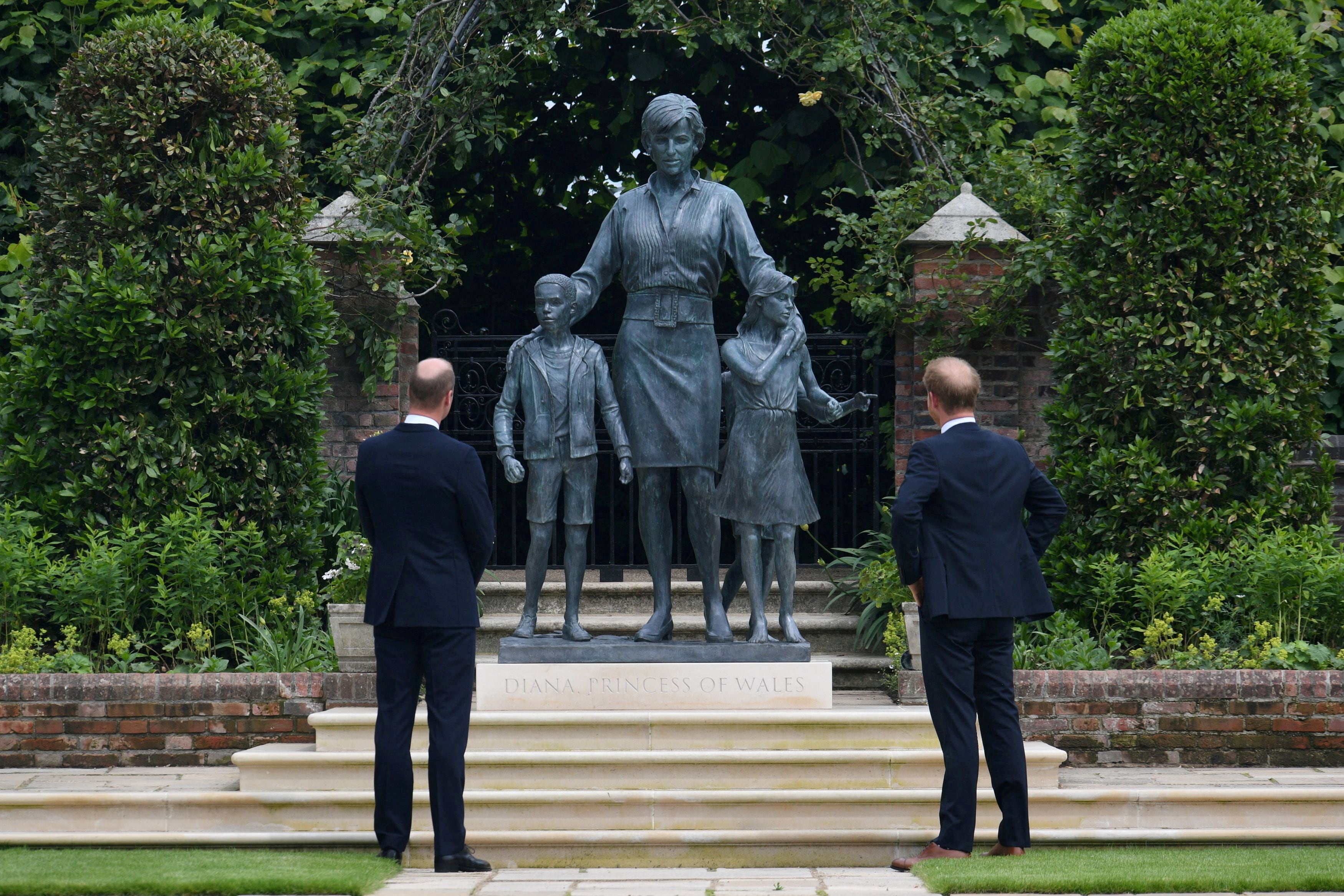 El príncipe Guillermo de Gran Bretaña, duque de Cambridge, y el príncipe Enrique, duque de Sussex, observan una estatua que encargaron de su madre, Diana, princesa de Gales, en el Jardín Hundido del Palacio de Kensington, Londres, Gran Bretaña, el 1 de julio de 2021. (Dominic Lipinski/Pool vía REUTERS/Foto de archivo)