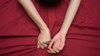 hand grasping on bed sheet