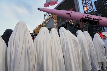 Un grupo de chicas posa junto a un misil Khaybar-buster durante una boda colectiva de parejas que participan en la campaña pro régimen Janfada (Sacrificio por Irán) en Teherán, Irán, el lunes 18 de mayo de 2026 (AP/Vahid Salemi)