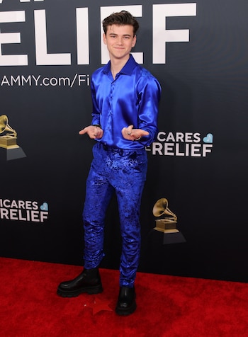 Alexander James Rodríguez, cantante y actor, con un llamativo conjunto azul eléctrico compuesto por una camisa satinada y pantalones con un intrincado diseño de textura