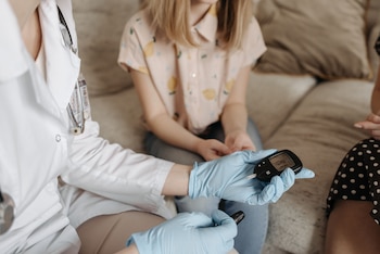 Una niña con diabetes se mide el azúcar en sangre