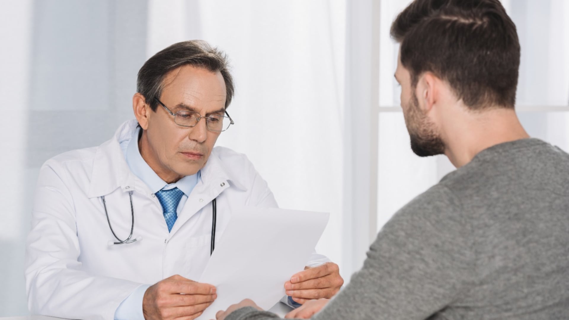 Un médico evalúa los exámenes de un paciente durante una consulta sobre infertilidad masculina en Perú.