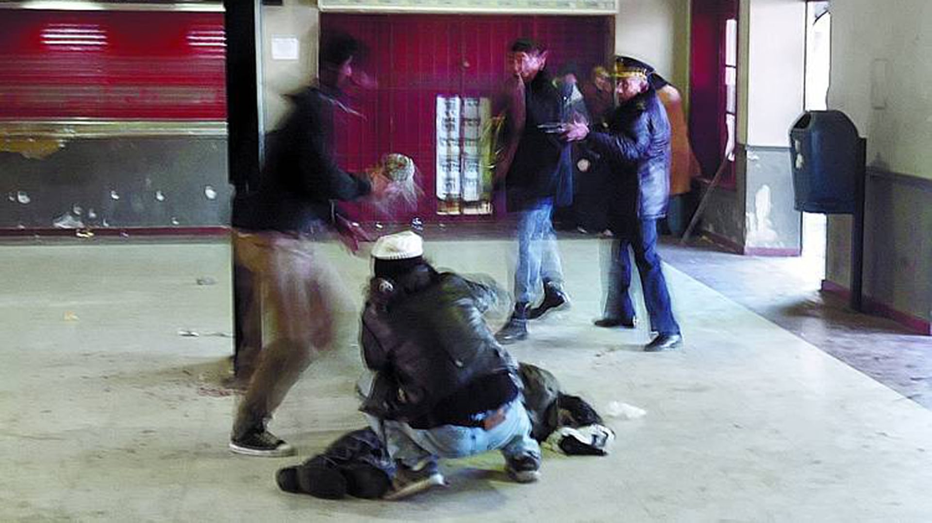 El excomisario Alfredo Fanchiotti apunta con su arma en la estación de Avellaneda. Kosteki está en el suelo, agoniza. Darío Santillán, en cuclillas y de espalda, se cubre. Poco después fue ejecutado (Pepe Mateos)