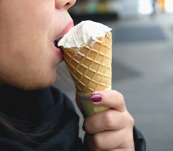 Una mujer comiendo un helado de cono (Magnific)