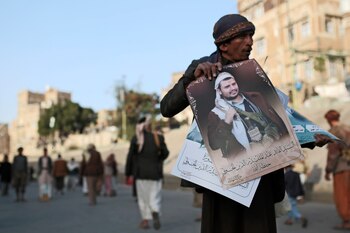Un vendedor yemení muestra retratos