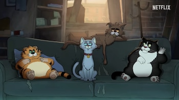 Cuatro gatos animados sentados en un sofá verde: uno naranja, uno gris con collar rojo, uno delgado marrón y uno blanco y negro. Logo de Netflix (YouTube: Netflix)