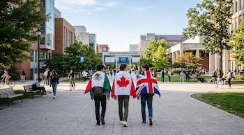 Tres personas caminan de espaldas por un campus universitario cubiertas con las banderas de México, Canadá y Reino Unido