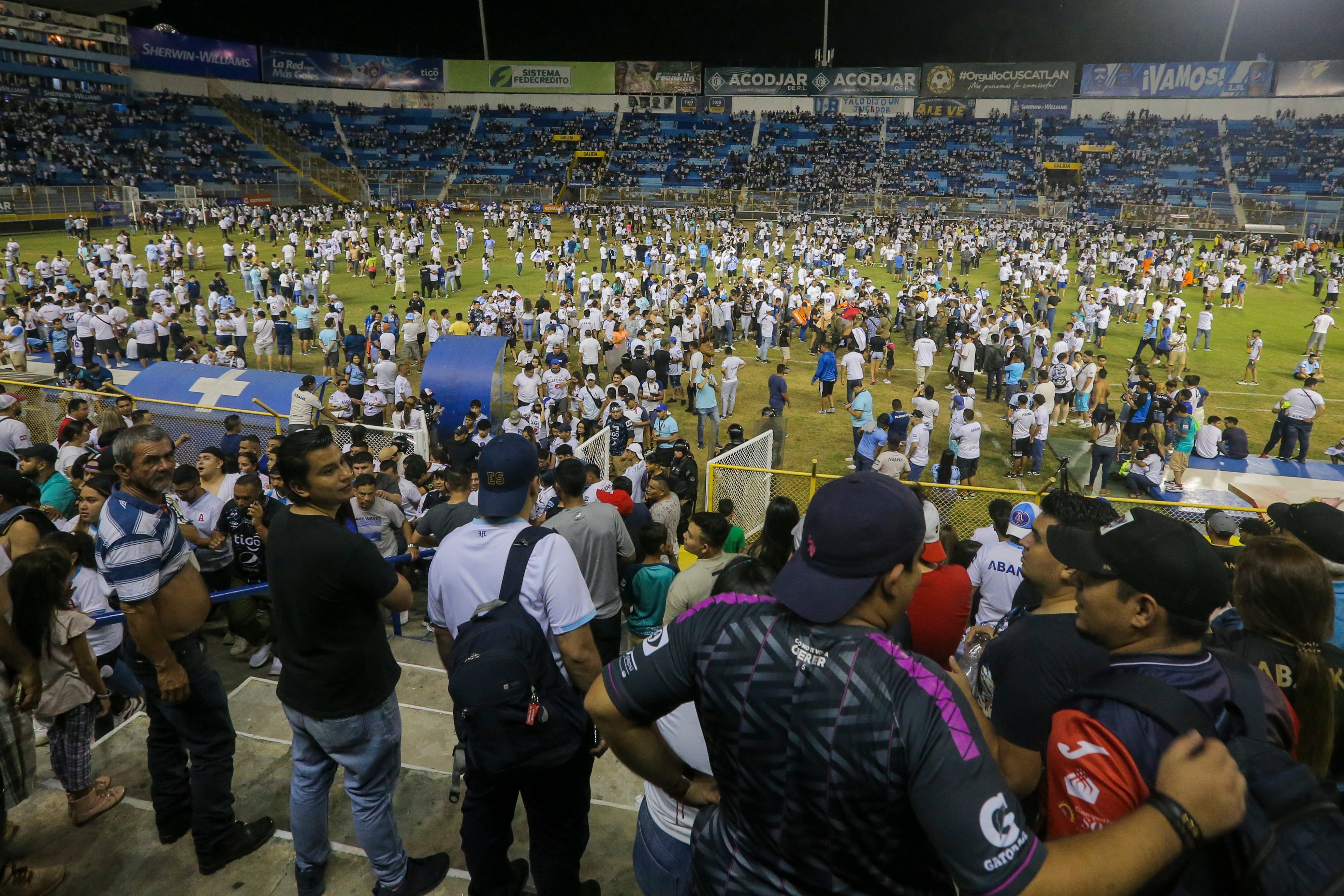 Hinchas en el campo del estadio Cuscatlán en San Salvador, El Salvador, el sábado 20 de mayo de 2023. Doce personas murieron y más de 100 resultaron lesionadas tras una estampida cuando la gente intentó derribar una puerta de acceso. (AP Foto/Milton Flores)