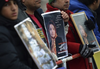Manifestantes sujetan fotos de la abogada y defensora de los Derechos Humanos iraní Nasrin Sotudeh frente a la embajada de Irán en Berlín, cuando fue encarcelada en la prisión de Evin de Teherán. EFE/Britta Pedersen