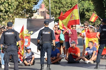 Ciudadanos impiden el acceso a miembros de Cruz Roja para entregar alimentos a los migrantes en la playa del Trampolín, este jueves en Ceuta. (EFE/Reduan)