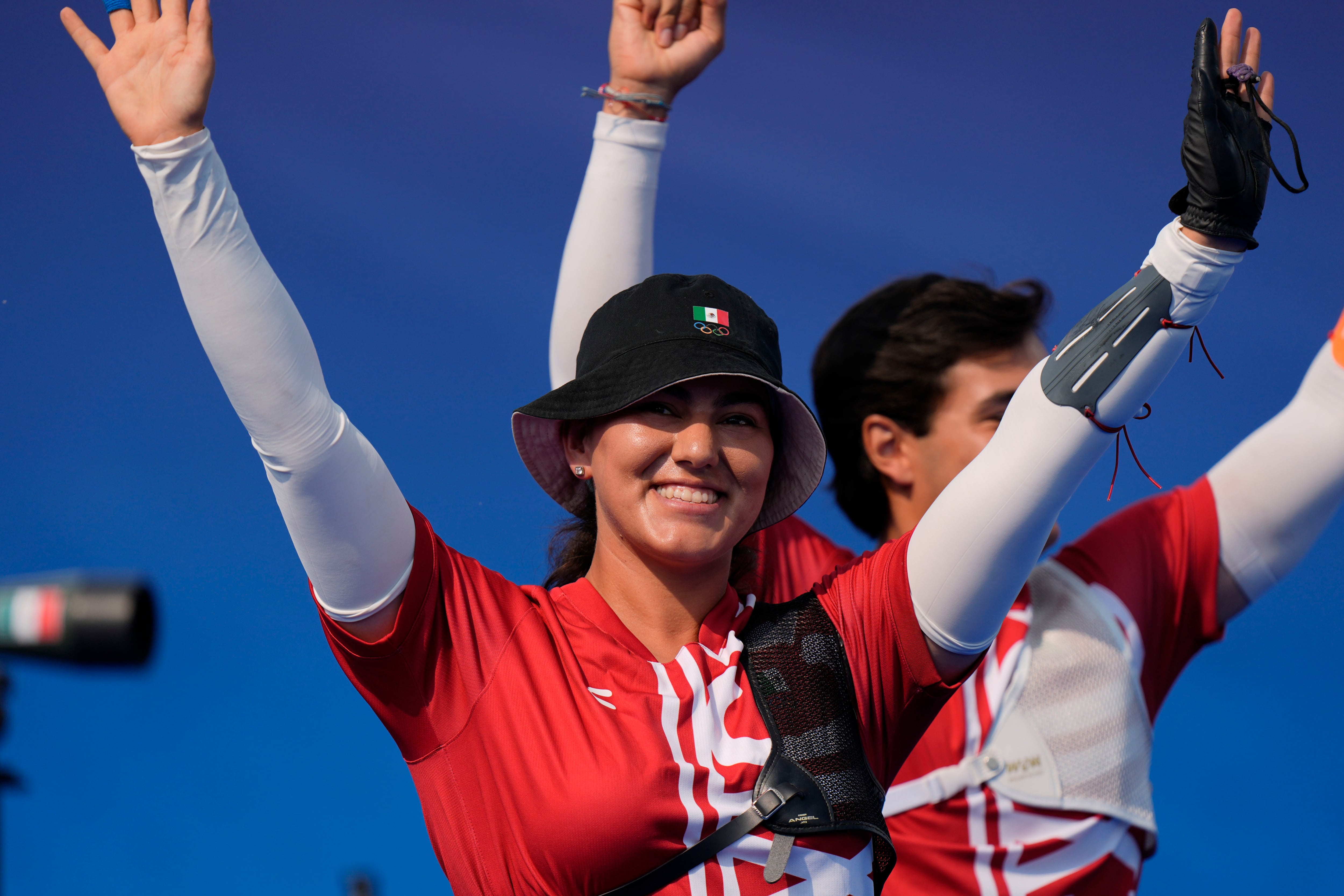 Alejandra Valencia, a la izquierda, y Matás Grande, de México celebran su victoria sobre Brasil en la ronda eliminatoria del tiro con arco en la prueba por equipos mixtos el viernes 2 de agosto de 2024, en París, Francia. (AP Foto/Brynn Anderson)