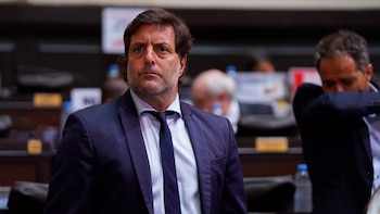 Fernando Rovello, un hombre de mediana edad con cabello oscuro y barba incipiente, vistiendo un traje azul oscuro y corbata, en un recinto