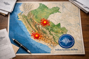 Mapa físico de Perú con puntos rojos y anaranjados, logo y texto "Instituto Geofísico del Perú", papeles con gráficos sísmicos y una lapicera en escritorio de madera.