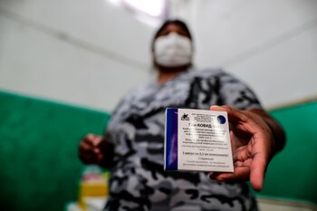 Una mujer muestra su carné