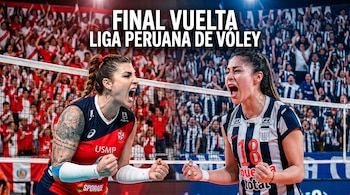 Primer plano de dos jugadoras de voleibol gritando con emoción en medio de la cancha, con una red entre ellas y aficionados animando en el fondo.