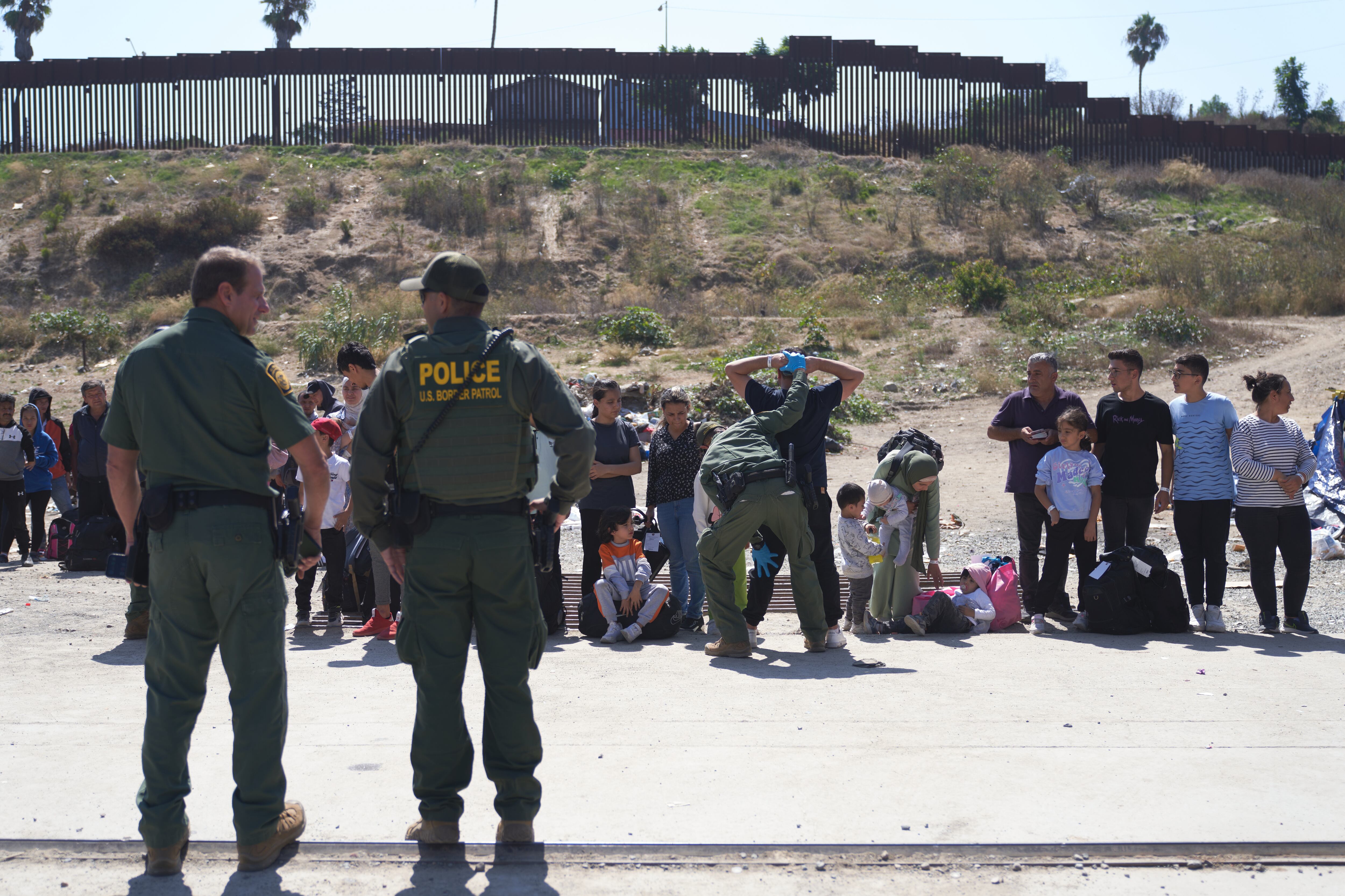 Agentes de la Patrulla Fronteriza de Estados Unidos procesan a migrantes en la frontera sur de EE.UU. con México en San Diego, California. EFE/Allison Dinner