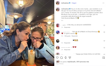 Melissa Loza y una mujer mayor bebiendo de un mismo vaso con pajitas, decorado con una rodaja de naranja, en un restaurante con luces colgantes
