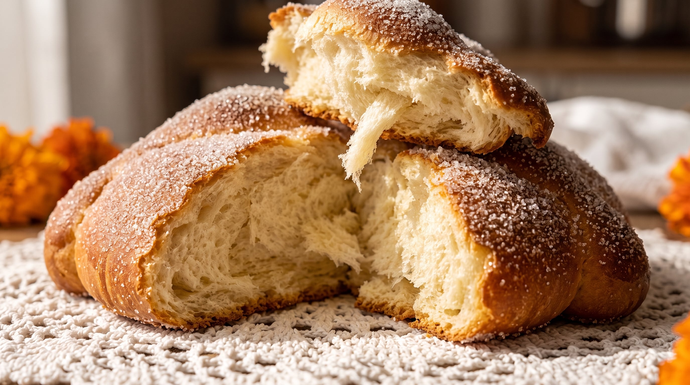 Un pan de muerto cubierto de azúcar permanece abierto sobre un mantel blanco durante las celebraciones del Día de Muertos en México. (Imagen Ilustrativa Infobae)