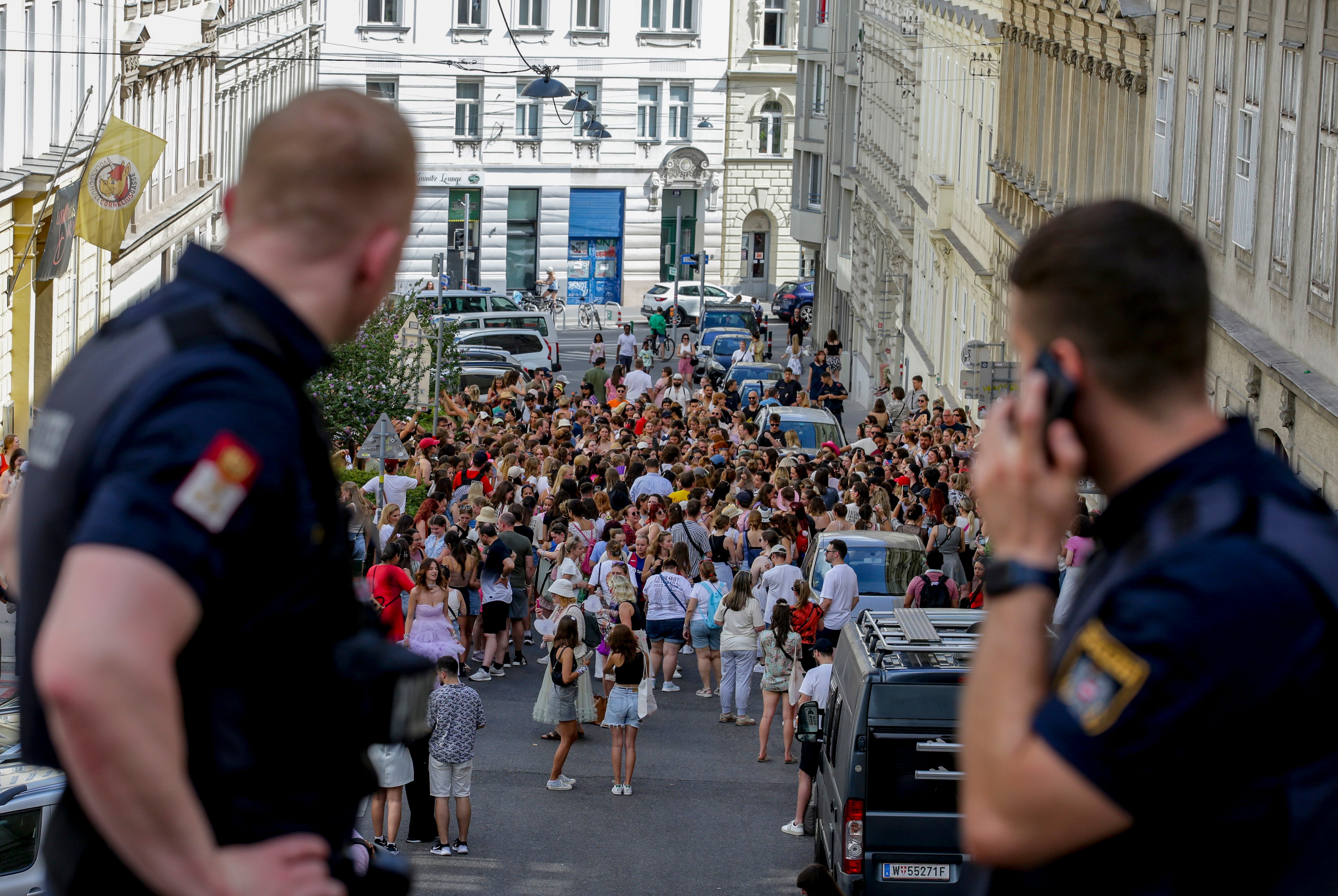 Policías austríacos observan a admiradores de Taylor Swift reunidos en el centro de la ciudad en Viena, el jueves 8 de agosto de 2024. (AP Foto/Heinz-Peter Bader)