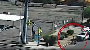 Vista aérea de una calle en el Centro de Phoenix con un camión blanco, un padre y un objeto en la acera; postes y edificios al fondo