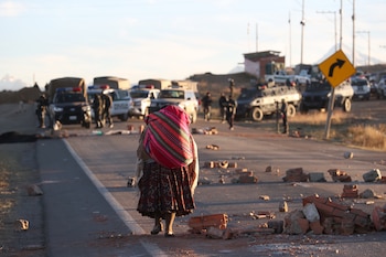 Una persona camina por una carretera bloqueada con escombros en Achica Arriba (Bolivia). EFE/ Luis Gandarillas