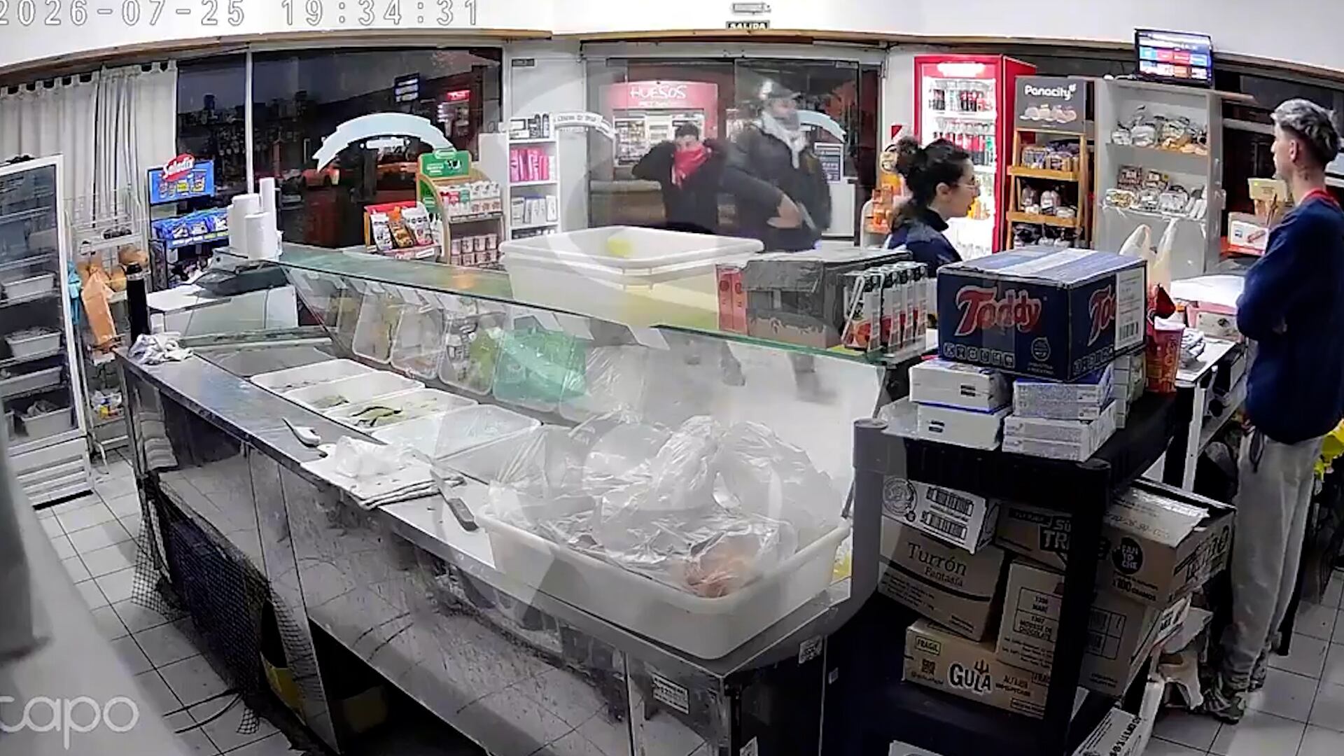 El momento en que los asaltantes irrumpieron en el comercio a punta de pistola.