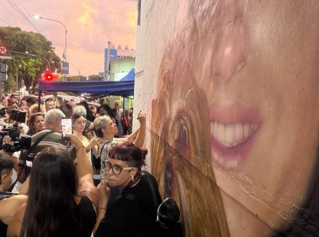 Una multitud se congrega frente a un mural que retrata a Wanda Taddei, en un acto de memoria y reclamo por la lucha contra el femicidio en Argentina.