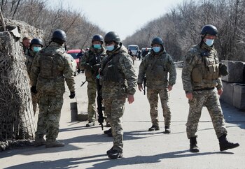 Foto de archivo: Miembros del Servicio Estatal de Guardia de Fronteras de Ucrania con máscaras protectoras son vistos en la línea de contacto entre las tropas ucranianas y los rebeldes prorrusos en Mayorsk, Ucrania, el 17 de marzo de 2020 (REUTERS/Gleb Garanich)