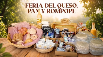 Botellas de rompope, cestas con pan dulce y galletas, paquetes de queso y tortillas de maíz sobre una mesa de madera al aire libre.