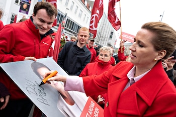 La primera ministra de Dinamarca y líder de los socialdemócratas, Mette Frederiksen (d), firma un cartel electoral mientras se reúne con votantes el día de las elecciones, en la plaza Nytorv, en Aalborg, Dinamarca, el 24 de marzo de 2026
EFE/EPA/HENNING BAGGER DENMARK OUT