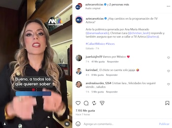 Mujer con cabello largo y rubio, camisa negra con botones dorados, hablando en un video. Se observa un fondo con estante, libros y una lámpara