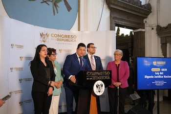 Un grupo de personas permanece ante un atril del Congreso de la República junto a una pantalla que anuncia una iniciativa de ley